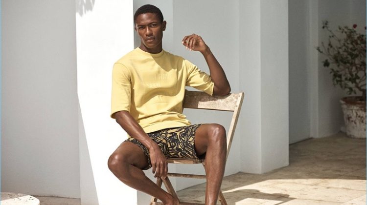 A vision in yellow, Hamid Onifade wears a H&M short-sleeved sweatshirt $19.99 with knee-length cotton shorts $24.99, and slip-on leather mules $39.99.