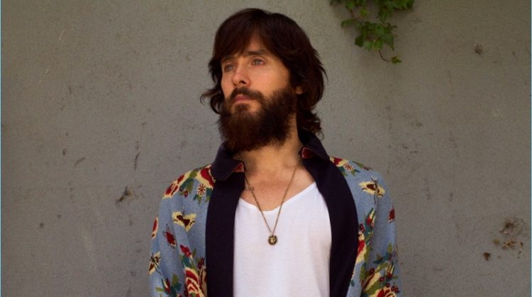 Jared Leto sports a necklace and floral print Gucci cape. He also wears a Sunspel tank and Alexander McQueen trousers.