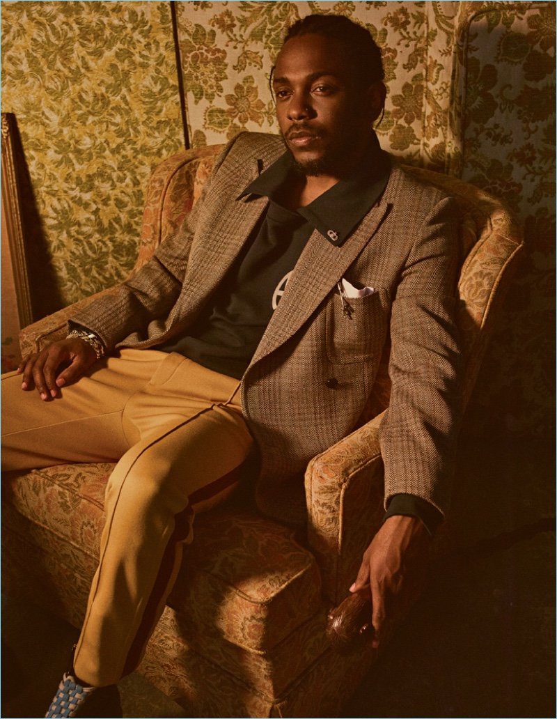 Appearing in an Interview shoot, Kendrick Lamar wears a Stella McCartney blazer and Gosha Rubchinskiy polo. He also sports a Neil Barrett pocket square, Coach side stripe trousers, and Gucci boots.