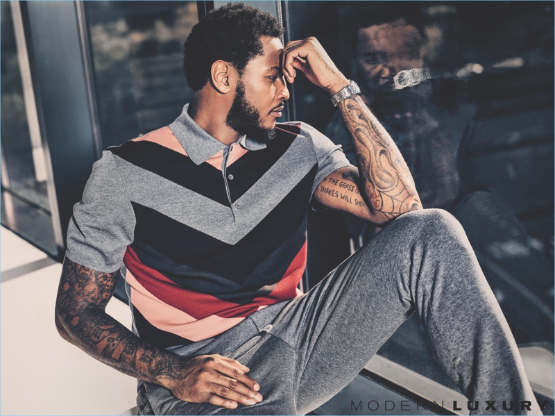 Stealing a moment of contemplation, Carmelo Anthony wears a knit polo and trousers by Bottega Veneta.