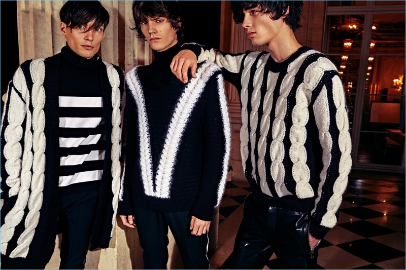 Models Victor Goujon, Elias de Poot, and Oussama Guessoum don knitwear from Balmain's pre-fall 2018 men's collection.