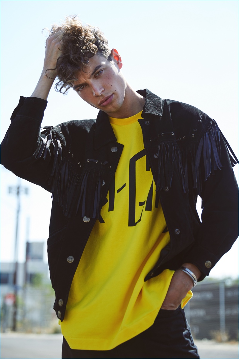 French model Camille Staron sports a fringed jacket with a colorful yellow tee.