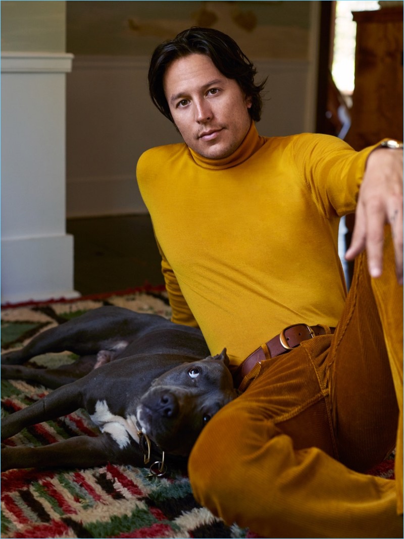 Cary Fukunaga dons a yellow turtleneck from Z Zegna with Sandro pants and a Tom Ford belt.