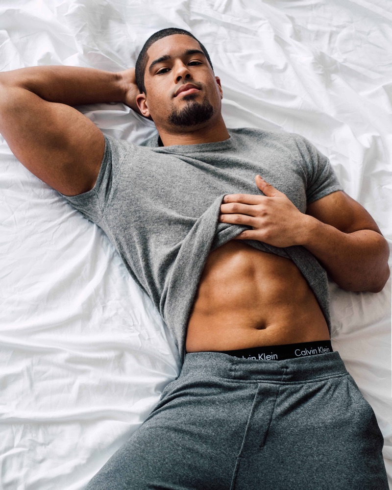 Laying in bed, Anthony Bowens stars in a photo shoot for Gay Times.