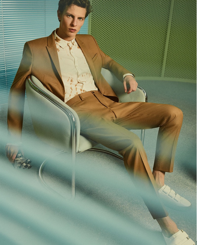 Tim Schuhmacher dons a trim tailored brown suit by Zara Man.