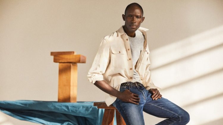 Medium Denim: A chic vision, Armando Cabral wears distressed denim jeans with an off-white oversized shirt.