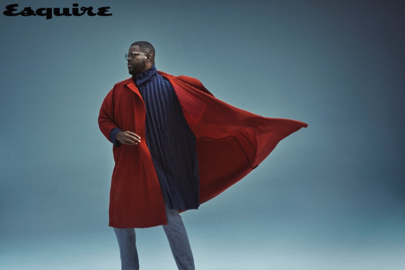 A smart vision, Winston Duke sports a Homme Plissé Issey Miyake overcoat and coat with Issey Miyake Men trousers.