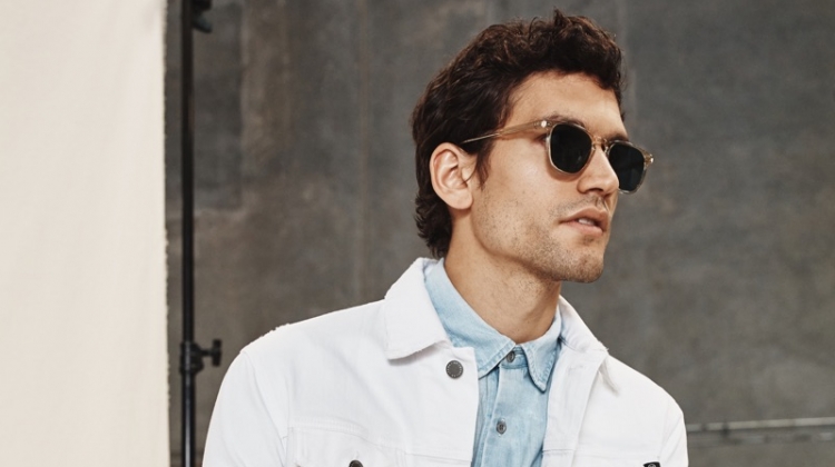 Sporting a white denim jacket and other pieces, Alfredo Nemer wears a look from AG Jeans' spring-summer 2020 collection.