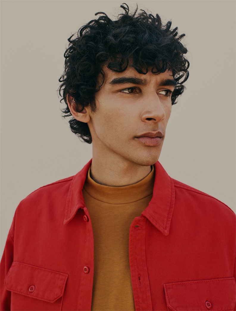 Callum Stoddart rocks a red denim jacket with a mock neck top.