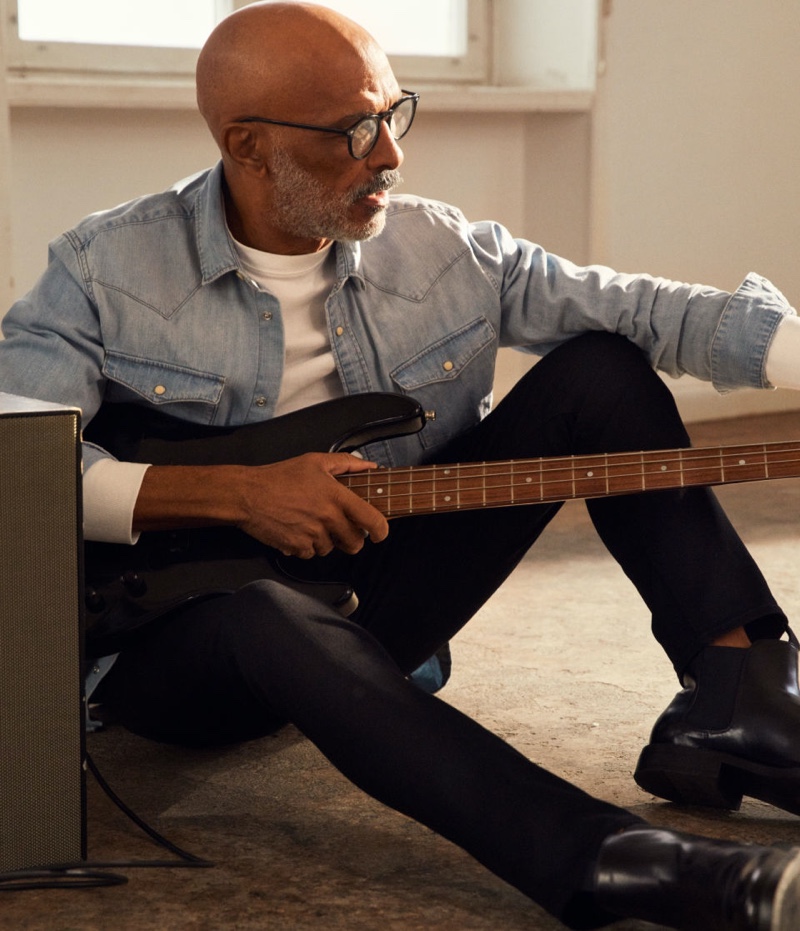 Tuning an electric guitar, Lono Brazil wears H&M's Freefit slim jeans.