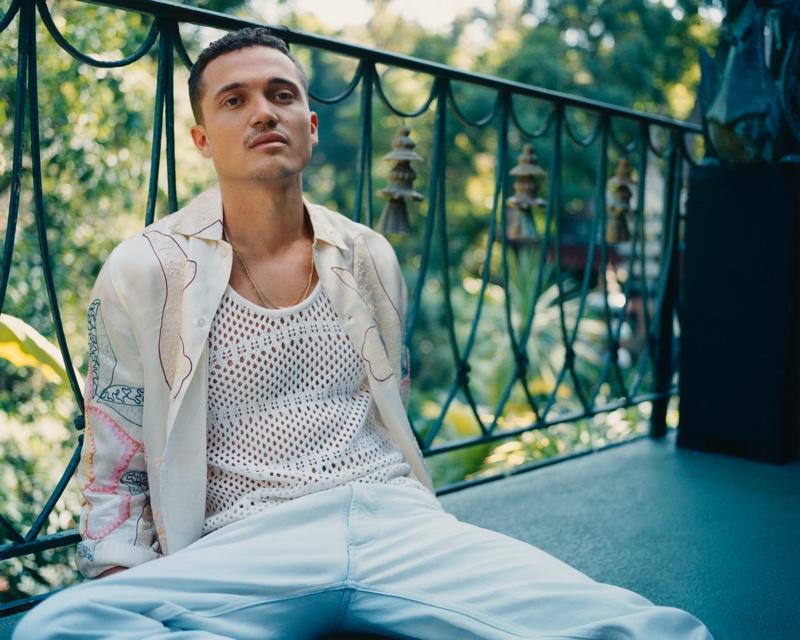 Actor Karl Glusman inspires in spring style for Mr Porter. Pictured outside, he wears an AMIRI crocheted tank, Bode embroidered satin-twill shirt, and Maison Margiela jeans.