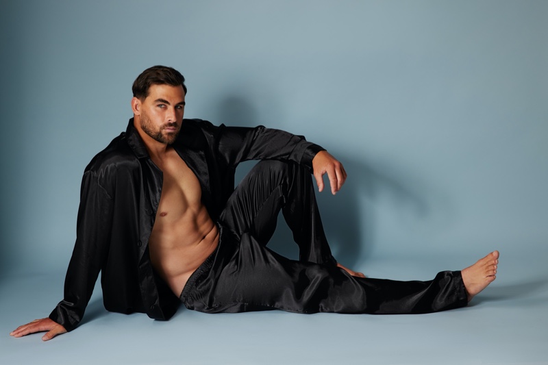 Model Marc Jacobs wears a black satin pajama set from Frederick's of Hollywood.