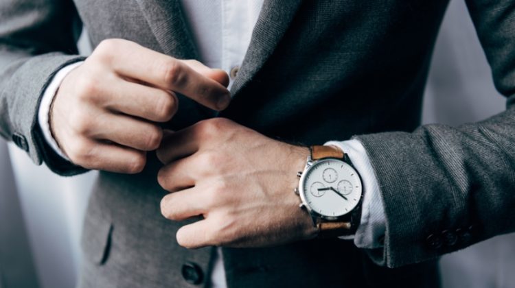 man wearing watch with brown leather strap