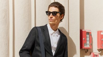 Model Justin Eric Martin wears a short suit with a linen shirt and D-frame sunglasses.