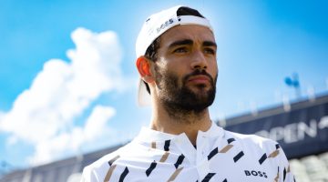 Sporting a backward cap, Matteo Berrettini showcases a houndstooth polo shirt from his BOSS capsule collection.