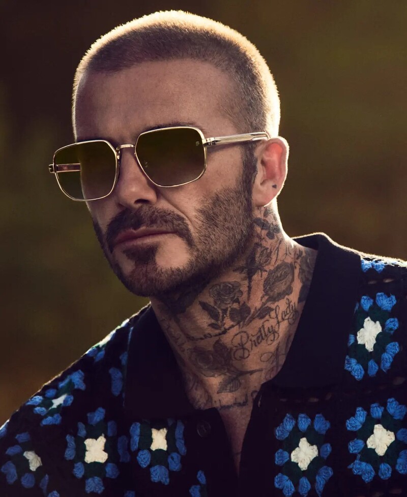 Sporting a buzz cut, David Beckham wears gold-framed sunglasses for his spring-summer 2024 eyewear campaign.