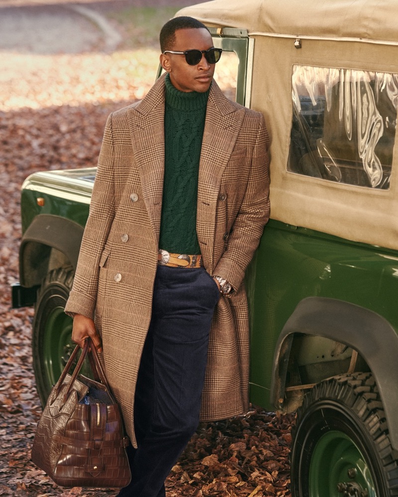 Oliver Kumbi wears a green cable-knit turtleneck with a double-breasted coat from Ralph Lauren Purple Label.