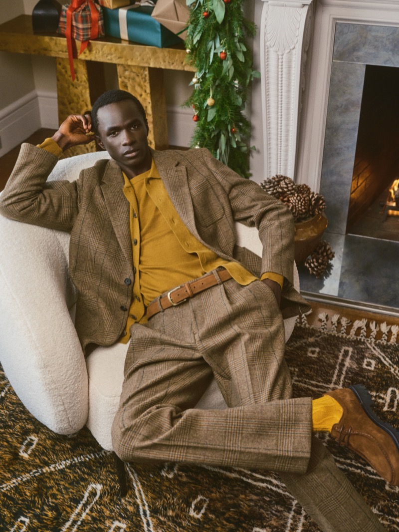 Embracing browns and mustard yellow, Malick Bodian wears a look from Banana Republic’s holiday 2024 collection.